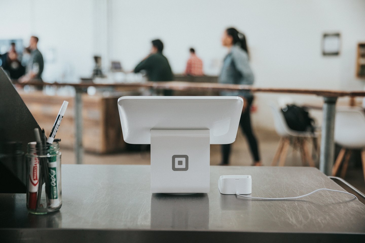 White point-of-sale terminal on a metallic counter.
