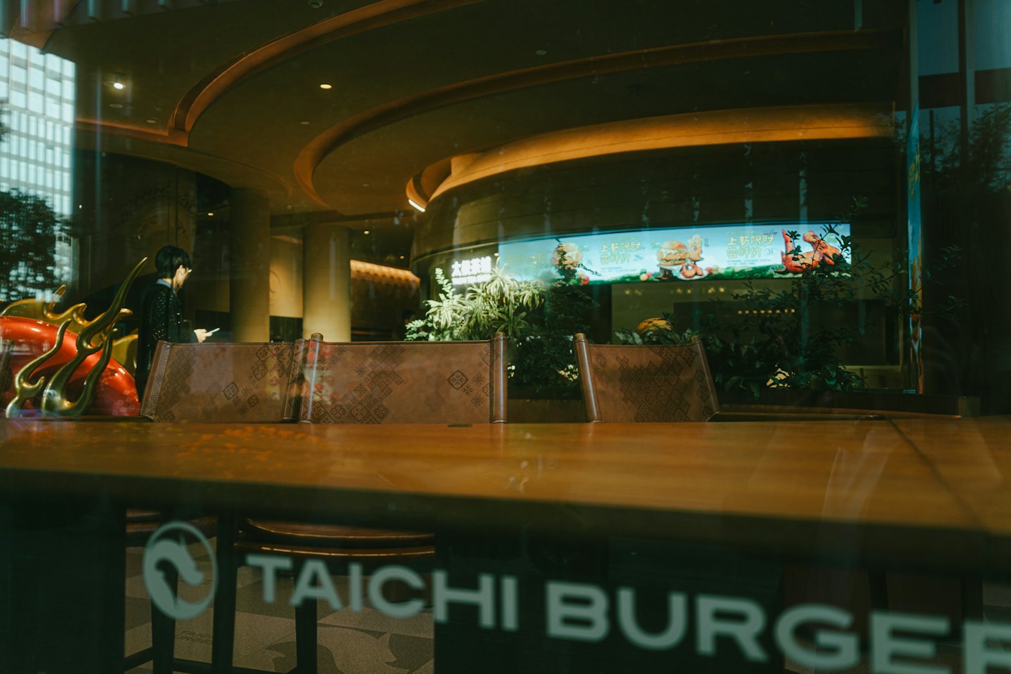 Modern cafe interior with wooden tables and a digital menu.